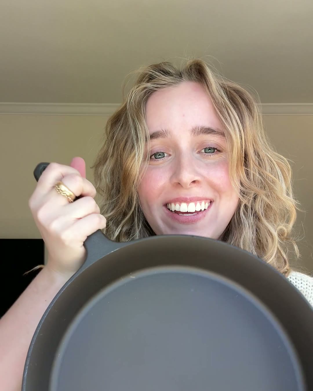 Katie, a food stylist, smiling in her kitchen and holding a No.10 Field Skillet