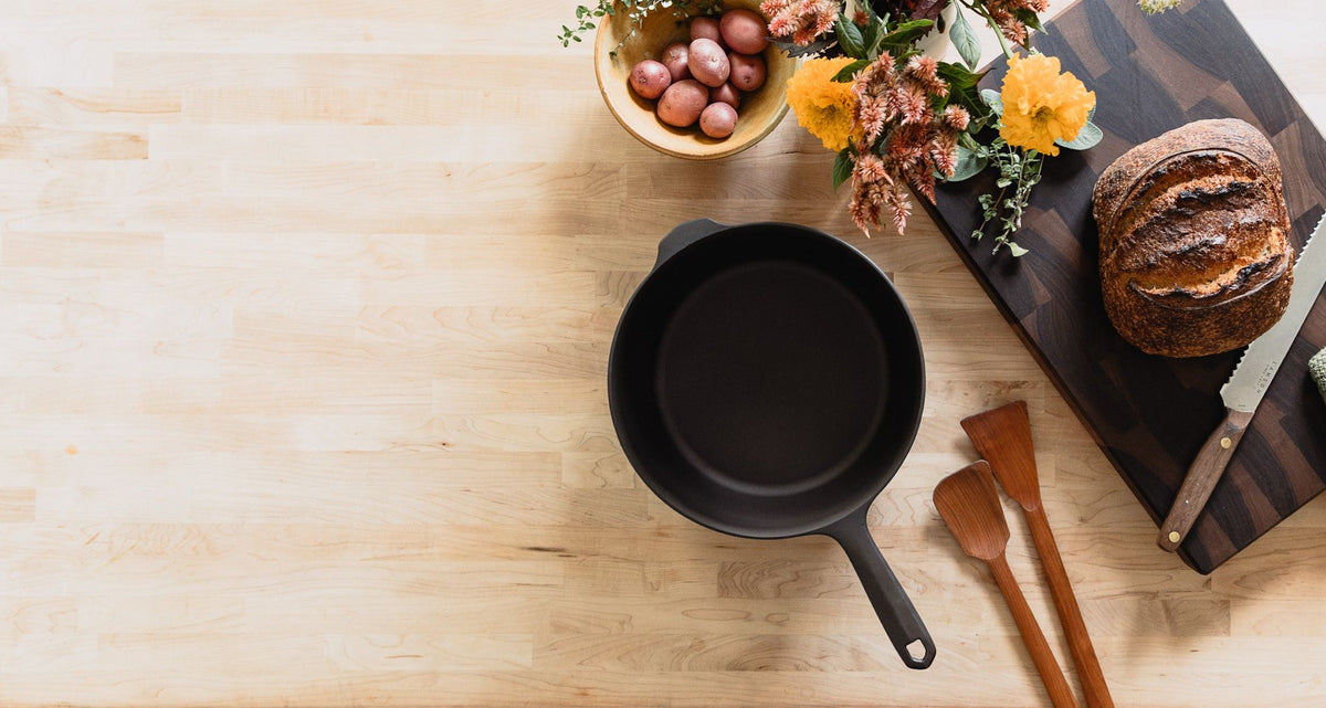 Field skillet on a wood table with bread and flowers