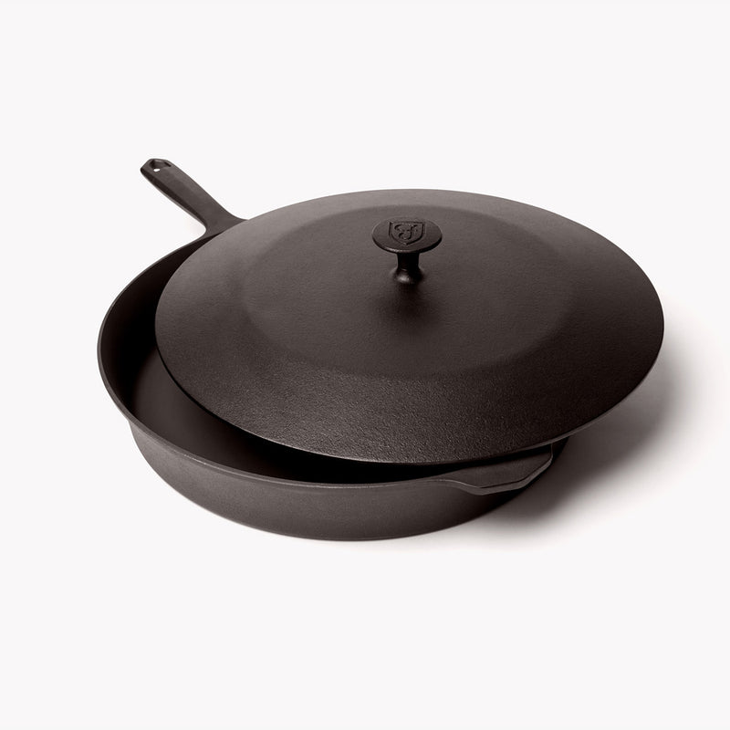 Cast iron lid resting slightly offset on the No.12 Field Skillet, angled view